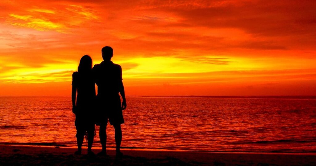 Couple walking on a romantic Goa beach at sunset